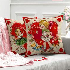 two pillows on a couch with hearts