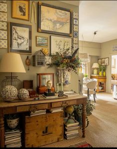 a living room filled with lots of furniture and pictures on the wall above it's table