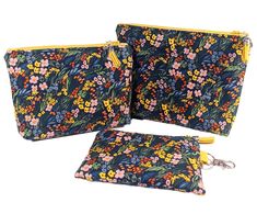 three zippered pouchs with floral print on the front and side, one has a key