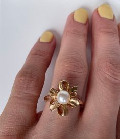 This is a fun floral pearl ring crafted in the Mid-Century era. The ribbon like petals form a large floral bow with has great finger coverage. This is a sweet feminine look. 14K Yellow Gold Weight: 4.59g size 6 (sizable upon request) People have coveted natural pearls as symbols of wealth and status for thousands of years. A Chinese historian recorded the oldest written mention of natural pearls in 2206 BC. As the centuries progressed toward modern times, desire for natural pearls remained stron Vintage White Flower Rings, Vintage Pearl Rings As Gift, Flower Shaped Pearl Ring For Wedding, Gold Flower Ring Pearls, Elegant Flower-shaped Pearl Ring For Weddings, Vintage 14k Gold Pearl Ring, Gold Flower-shaped Pearl Ring For Wedding, Elegant White Flower-shaped Pearl Ring, Luxury Antique Gold Pearl Ring