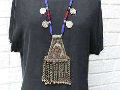 This vintage tribal medallion necklace strung with glass beads and old Afghani coins goes easily right over the head.  And with the 3"inch dangling bell chain, it is perfect for belly dancers or anyone interested in making a statement. Size:  Length: 19"inches            Pendant: 6"inches long with dangling tassels x 3"inches wide.  It dominates the necklace Condition:  Excellent. A few missing glass beads in the medallion, but otherwise no issues.  In fact, you do not even know the beads are mi Festival Medallion Necklace With Coin Pendant, Festival Coin Pendant Necklace In Medallion Shape, Festival Coin Pendant Medallion Necklace, Silk Route, Medallion Necklace, Belly Dancers, Favorite Things Gift, The 3, 6 Inches