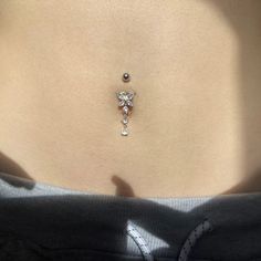 a woman's stomach with a small diamond necklace on her left side, and the bottom part of her belly visible