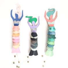 three little mermaid doll clothes hanging from hooks with text overlay that says egg carton mermaid dolls