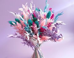 a vase filled with lots of different colored feathers