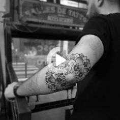 a man with a flower tattoo on his arm