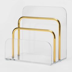 three clear and gold nesting tables with metal handles on each side, against a white background