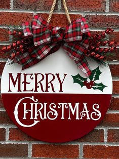 a merry christmas sign hanging on a brick wall