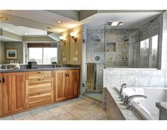 a large bathroom with two sinks and a bathtub next to a walk in shower