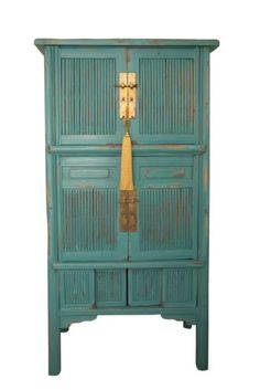 an old wooden cabinet with two doors and a tassell hanging on the door