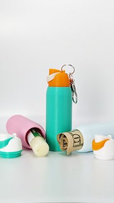 an assortment of baby bottles and pacifiers on a white surface with a keychain