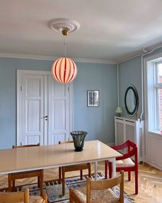 a dining room table with chairs and a vase on the table in front of it