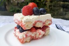 a piece of cake with berries and cream on top