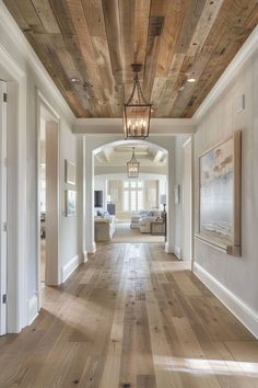 an empty hallway with wood floors and white walls