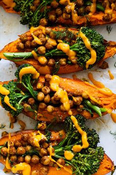 baked sweet potatoes with broccoli and chickpeas on top, topped with mustard sauce