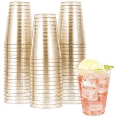 a set of four gold cups and a glass with a lemon slice on the side