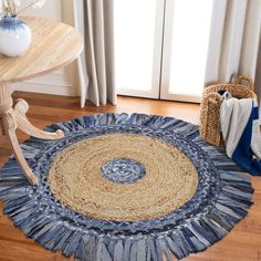 a blue and beige area rug on the floor next to a table with a basket