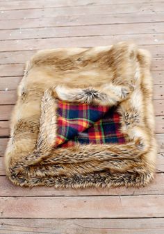 a plaid blanket is laying on a wooden floor