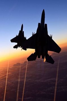 an air force jet flying through the sky at sunset with jets trailing behind it in formation