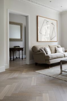 a living room filled with furniture and a painting on the wall