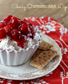 a dessert with strawberries on top and crackers in the middle is sitting on a red tablecloth