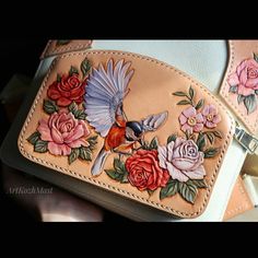 a hand painted purse with flowers and a bird on it