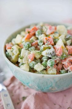 a bowl filled with salad sitting on top of a pink napkin next to a fork