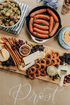 an assortment of pretzels, grapes, apples, and other snacks on a table