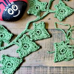 green crocheted flowers and a rock on a wooden floor