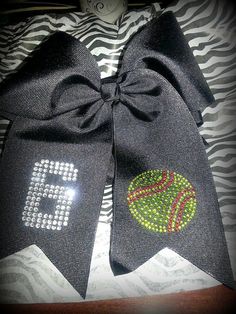 two black bows with green and red balls on them, one has the number six