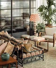 a living room filled with lots of furniture next to a fire place covered in potted plants