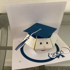 an origami graduation hat on top of a piece of paper with a graduate's cap