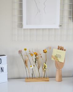 some flowers are sitting on a desk next to a sign