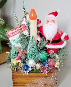 a christmas arrangement in a wooden box with santa clause