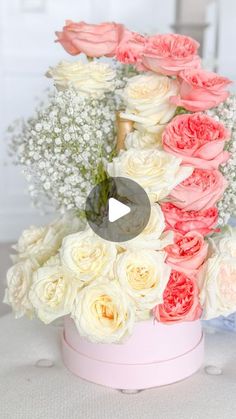 a pink vase filled with lots of white and red flowers on top of a table