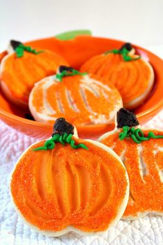 three decorated pumpkin cookies sitting on top of a table