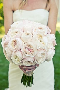 a bride holding a bouquet of white roses