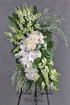 white flowers and greenery are arranged on an easel with the words grand repesible