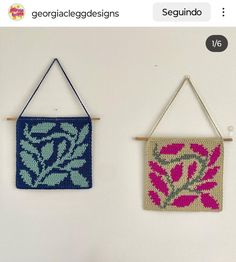 two crocheted wall hangings with flowers and leaves on them, one is blue and the other is pink