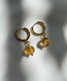 Citrine Hoop Earrings. A classic hoop earring with faceted citrine. Shown with additional pieces for styling inspiration but not included Earrings measures approximately 1.5” Earring is gold filled Each piece is unique in color and stones and may vary from the picture