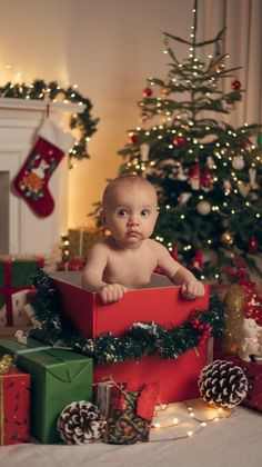 a baby sitting in a box surrounded by christmas presents