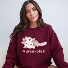 a woman sitting on top of a couch wearing a maroon sweatshirt with an animal nurse on it