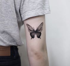 a woman's arm with a butterfly tattoo on the back of her left arm