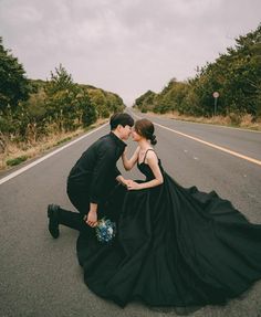 a man and woman are kissing on the road