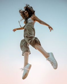 a person jumping in the air on a skateboard with their legs spread out and one foot up