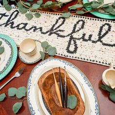 the table is set with plates, cups and utensils