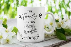 the family union is our greatest walter coffee mug on a table with white flowers and greenery