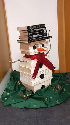 a stack of books sitting on top of a snowman made out of stacked books