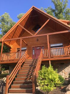 a wooden cabin with stairs leading up to the front door