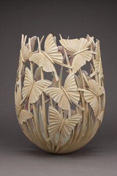 a vase with leaves carved into it