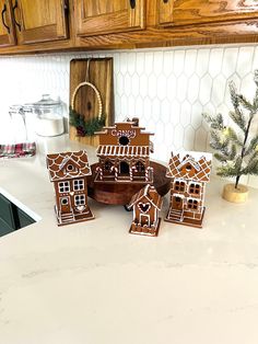 several gingerbread houses on a kitchen counter